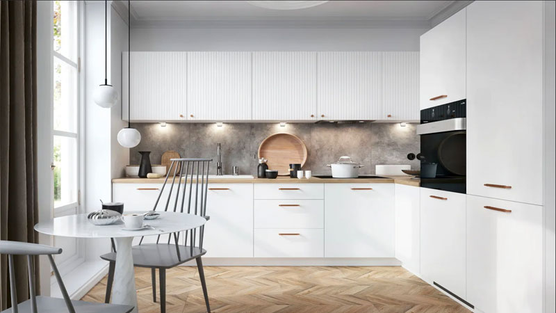 Elegante maßgeschneiderte Küche mit weißen Fronten in zwei Stilen sowie goldenen Griffen, funktional.
